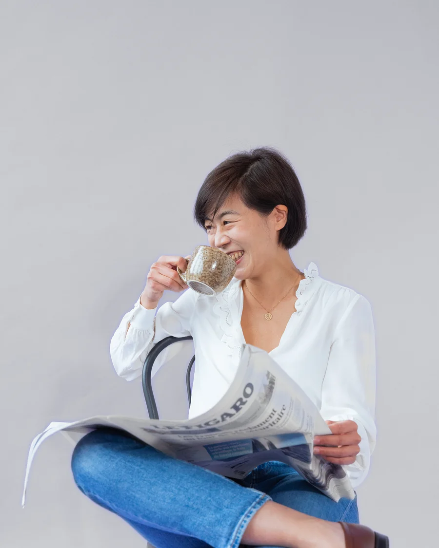 Claire Wang reading Le Figaro over coffee
